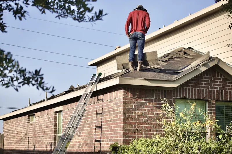 Professional roofer working on a residential roof in Winding River